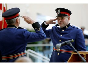 Edmonton Police Service Const. Scott Bailey, right, salutes police Chief Rod Knecht during the 2017 graduation of Bailey's recruit training class. A charge of assault causing bodily harm against Bailey stemming from a 2022 domestic incident was withdrawn Nov. 9.