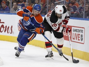 Edmonton's Kris Russell (4) battles New Jersey's Devante Smith-Pelly (25) during the first period of a NHL game between the Edmonton Oilers and the New Jersey Devils in Edmonton, Alberta on Thursday, January 12, 2017.