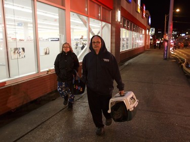 Evacuees Allayne (left) and David Cunningham with cat Smokey are seen on the street during a fire at the Oliver Place apartment complex at 117 Street and Jasper Avenue in Edmonton on Thursday, Jan. 19, 2017. Five hundred people were evacuated in the two alarm fire.