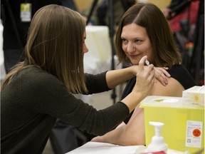 Associate minister of health Brandy Payne receives a flu shot at the East Edmonton Public Health Centre this past October.