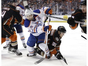 Edmonton Oilers' Jordan Eberle, center left, goes after the puck as Anaheim Ducks' Jakob Silfverberg, of Sweden, falls to the ice during the first period of an NHL hockey game on Feb. 26, 2016, in Anaheim, Calif.