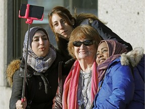 Norquest College students Alaa Mouselli, Maya Chmait and Noha Ibrahim (left to right) talke a "selfie" with their teacher Joan Porter at Rundle Park in Edmonton on January 26, 2017. A group of students from NorQuest College's Language Instruction for Newcomers to Canada (LINC) program, many of whom are experiencing their first winters in Canada, attended an all-day winter festival, which included cross country skiing, snowshoeing and bannock making.