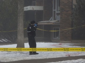 Police stand at the scene of a homicide at 11049 84 St. on Wednesday Jan. 21, 2017 in Edmonton. Alberta police are a step closer to a unified approach to releasing the names of homicide victims, Edmonton police Chief Rod Knecht said.