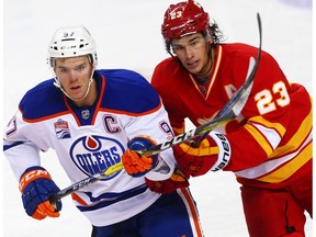 Edmonton Oilers Connor McDavid battles for the puck against Sean Monahan of the Calgary Flames during NHL hockey in Calgary, Alta., on Friday, October 14, 2016.