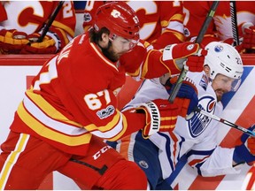 The Calgary Flames Michael Frolik checks the Edmonton Oilers' Matt Hendricks, during NHL action at the Scotiabank Saddledome in Calgary on Saturday January 21, 2017.