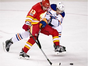 The Calgary Flames' Johnny Gaudreau and the Edmonton Oilers' Matt Benning battle for the puck during NHL action at the Scotiabank Saddledome in Calgary on Saturday January 21, 2017.