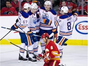 The Edmonton Oilers celebrate their 6th goal while dejected Calgary Flames defenceman Dennis Wideman kneels on the ice during second period NHL action at the Scotiabank Saddledome in Calgary on Saturday January 21, 2017.