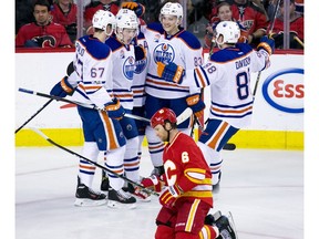 The Edmonton Oilers celebrate their 6th goal while dejected Calgary Flames defenceman Dennis Wideman kneels on the ice during second period NHL action at the Scotiabank Saddledome in Calgary on Saturday January 21, 2017.  GAVIN YOUNG/POSTMEDIA