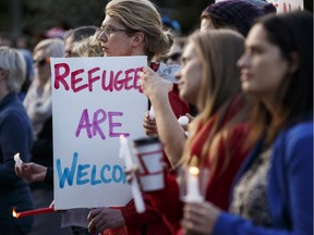 HSAA president Mike Parker writes about why his union sponsored a family of Syrian refugees. In a 2015 file photo, supporters hold candles and signs during a Refugees Welcome rally held at the Alberta Legislature in Edmonton on Sept. 8, 2015.