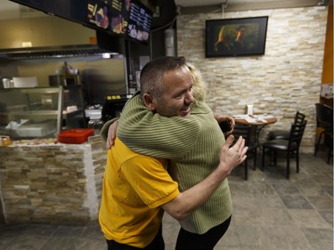 Riza Kasikcioglu (left), owner of Maximo's Pizza and Donair, gets a hug from Grace Williams, a fourth floor resident, after he ran to save people as a fire struck the Oliver Place apartment complex at 117 Street and Jasper Avenue in Edmonton on Thursday, Jan. 19, 2017. Five hundred people were evacuated in the two alarm fire.