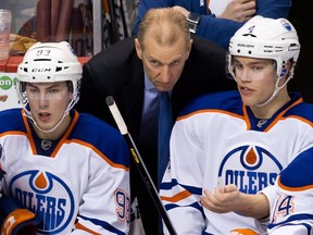 Edmonton Oilers' head coach Ralph Krueger, centre, talks to Taylor Hall, right, as Ryan Nugent-Hopkins, looks on during the third period of an NHL hockey game against the Vancouver Canucks in Vancouver, B.C., on Sunday January 20, 2013.