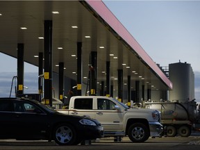 Vehicles fill up at a gas station. Whatever your beefs might be with the carbon tax, don't make them about race, says columnist Paula Simons.