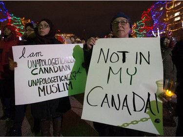 Several hundred people gathered with signs and candles in front of the Alberta Legislature on Monday, Jan. 30, 2017.