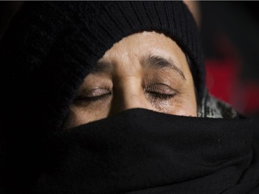 A woman cries as she takes part in a vigil in response to Sunday's deadly shooting at a Quebec City mosque in Edmonton, Monday Jan. 30, 2017.