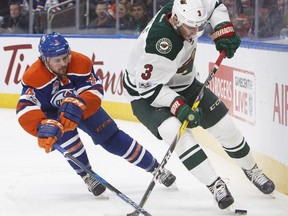 Minnesota Wild centre Charlie Coyle (3) and Edmonton Oilers defenceman Kris Russell (4) battle for the puck during first period NHL action in Edmonton, Alta., on Tuesday January 31, 2017. THE CANADIAN PRESS/Jason Franson ORG XMIT: EDM104