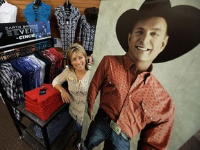 Jocelyne Lambert, general manager of Welsh's Saddlery and Western Wear, stands with a photo of singer Garth Brooks and his line of western shirts and jeans she hopes will appeal to fans attending his record nine Edmonton concerts Feb. 17 to 25.