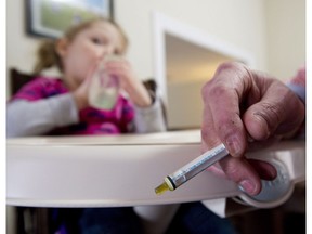 Alex Repetski (right) gives his two-year-old daughter Gwenevere oil-based medical marijuana to help control her seizures in Toronto on Tuesday, April 7, 2015. Gwenevere's epileptic seizures are being treated with cannabidiol, one of several active cannabinoids found in the marijuana plant. Richard Tang-Wai, a pediatric epileptologist at the University of Alberta, is part of a study to determine if the treatment is safe.