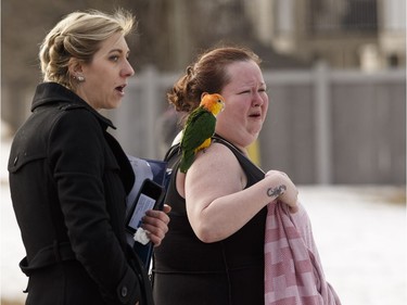 An evacuated resident worries for her birds as Edmonton Fire Rescue Services firefighters battle a blaze at Westridge Estates in Edmonton on Thursday, February 16, 2017. Ian Kucerak / Postmedia