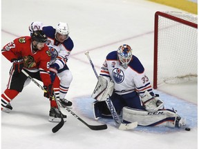 Edmonton Oilers goalie Cam Talbot (33) stops a shot by Chicago Blackhawks center Tanner Kero (67) as Oilers defenseman Andrej Sekera (2) pressures during the second period of an NHL hockey game Saturday, Feb. 18, 2017, in Chicago.