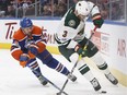 Minnesota Wild centre Charlie Coyle (3) and Edmonton Oilers defenceman Kris Russell (4) battle for the puck during first period NHL action in Edmonton, Alta., on Tuesday January 31, 2017.