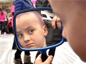 Corbin Lentz, 7, checks out the progress of his head being shaved in the mirror at Hair Massacure at West Edmonton Mall in Edmonton on Friday, Feb. 24, 2017.