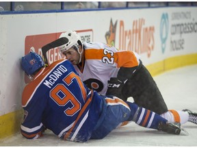 Connor McDavid of the Edmonton Oilers sits on the ice with a broken left clavicle after getting hit into the boards by Brandon Manning of the Philadelphia Flyers at Rexall Place on Nov. 3, 2015. (Shaughn Butts)