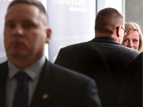 Premier Rachel Notley talks to the media while her security stands guard (L) after giving a speech. File photo.