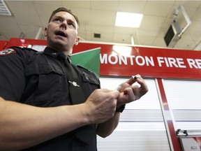 Edmonton Fire Rescue Services training officer Clint Snider demonstrates how a naloxone kit works, using an orange, as the government of Alberta announced greater access to lifesaving naloxone kits in Edmonton on Feb. 7, 2017.