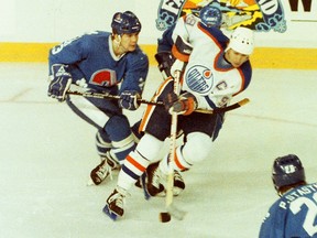 Quebec Nordiques centre Paul Gillis, left, battles Edmonton Oilers captain Wayne Gretzky during NHL action Feb. 14, 1986, at Edmonton's Northlands Coliseum.