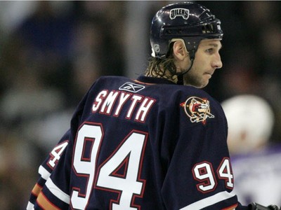 Edmonton Oilers' Ryan Smith tries to squeeze past San Jose Sharks