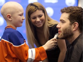 Edmonton Oilers' defenseman Eric Gryba has his beard shaved by Ethan Hughes, 10, for charity, at Rogers Place in Edmonton on Wednesday, Feb. 15, 2017.
