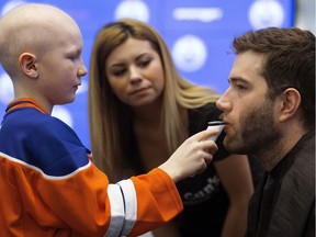 Edmonton Oilers defenceman Eric Gryba has his beard shaved by Ethan Hughes, 10, for charity, at Rogers Place in Edmonton Wednesday Feb. 15, 2017. Gryba was raising awareness for Garth Brooks' Teammates for Kids Foundation. Helping Ethan is Farrah Hart from Tommy Gun's Original Barbershop.
