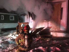 Firefighters tackle a blaze at an abandoned mobile home on Minto Street in Penhold, Alta.
