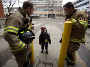 Edmonton firefighters Troy Farn, left, and Courtney Polson chat with Cedric Way, 6, before climbing onto the roof of Fire Station #2 at 10217 107 St. to start their annual Rooftop Campout in support of Muscular Dystrophy Canada on Tuesday, Feb. 21, 2017. Cedric has Duchenne muscular dystrophy.