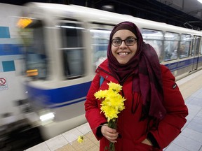 Nakita Valerio (right) with the Alberta Muslim Public Affairs Council, hands out flowers to women wearing hijabs at the University of Alberta LRT station on Dec. 7, 2016, after a man threatened two Muslim women on the LRT platform.