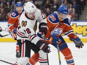 Brandon Davidson (88) of the Edmonton Oilers, pushes Artemi Panarin of the Chicago Blackhawks off the puck at Rogers Place in Edmonton on Feb. 11, 2017.