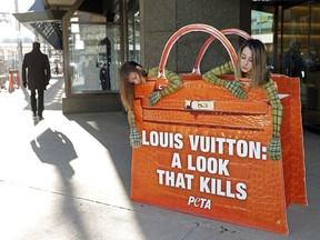 PETA (People for the Ethical Treatment of Animals) protesters Brenna Jonasson (left) and Carley McGrath,  adorned in body paint, endure the -15 C temperatures outside the Holt Renfrew store in downtown Edmonton on Feb. 2, 2017.