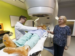 Radiation therapy student Merrill Singleton and volunteer patient and cancer survivor Jill Doiron pose for a photo with the linear accelerator inside the University of Alberta's new radiation therapy training suite at the Cross Cancer Institutre in Edmonton on Tuesday, February 21, 2017.