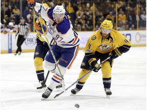 Edmonton Oilers center Connor McDavid (97) is defended by Nashville Predators' Ryan Ellis (4) during the first period of an NHL hockey game Thursday, Feb. 2, 2017, in Nashville, Tenn.