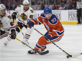 Ryan Nugent-Hopkins (93) of the Edmonton Oilers, tries to make a play in the offensive zone while being watched by Tanner Kero of the Chicago Blackhawks at Rogers Place in Edmonton on Feb. 11, 2017. Photo by Shaughn Butts  Jim Matheson Story Photos and video off Oilers vs. Blackhawks for copy running in Sunday, Feb. 12, 2017, editions.