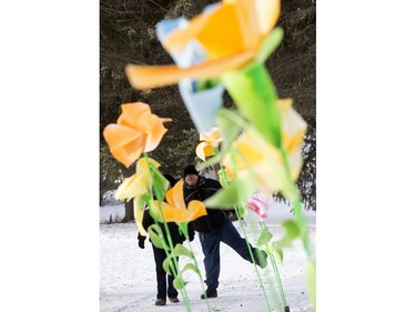 Visitors to the Silver Skate Festival are framed by sculptures of giant flowers as they walk through Hawrelak Park, In Edmonton Sunday Feb. 12, 2017. Photo by David Bloom