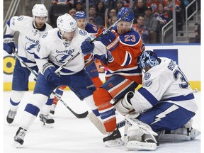 Tampa Bay Lightning Slater Koekkoek battles in front of the net with Edmonton Oilers' Matt Hendricks as goalie Ben Bishop makes the save in Edmonton on Dec. 17, 2016. (The Canadian Press)