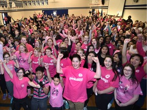 Students at H.E. Beriault Catholic Junior High School pose for photos while wearing pink shirts to stand up against bullying in Edmonton, Wednesday, February 22, 2017.