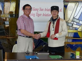 John Jeffries (left), president of Flying Tiger Aviation Ltd., shakes hands with Feng Ge, general manager of China's Shengda Xiang Yun Aviation Co. Ltd. in Wetaskiwin on Feb. 20, 2017, after the two companies agreed to set up a partnership primarily to build airplanes.