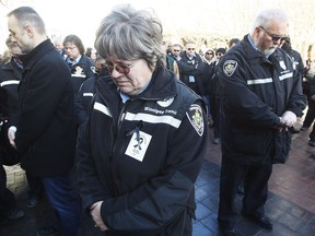 Winnipeg bus drivers take a moment of silence as they gathered to support each other at a rally for Irvine Fraser, who was killed by a passenger, and to demand safety improvements on buses outside city hall in Winnipeg, Friday, Feb. 17, 2017.