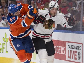 Edmonton Oilers forward Zack Kassian, left, knocks Chicago Blackhawks defenceman Brian Campbell off the puck at Rogers Place in Edmonton on Feb. 11, 2017.
