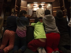 Nathan Chan shows students the organ as part of the Science of Sound program for children at the Winspear Centre for Music.