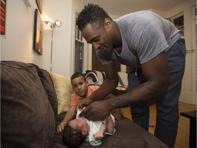 Jesse Lipscombe changes newborn son Indiana Lipscombe's outfit, while son Chile Lipscombe, 8, looks on, at their home, in Edmonton on Wednesday Nov. 9, 2016.