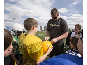 Offensive lineman Matt O'Donnell instructs young players during an Eskimos Amateur Football Camp at Clarke Field in Edmonton on May 12, 2014. (Ian Kucerak)