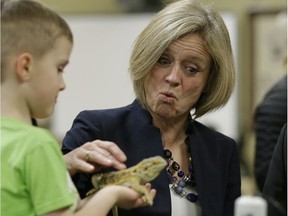 Alberta Premier Rachel Notley meets a lizard at Monsignor Fee Otterson School in southwest Edmonton on Friday March 17, 2017, where she met with parents and educators to talk about the provincial budget.